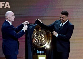 Presiden FIFA, Gianni Infantino bersama bekas bintang Brazil,  Ronaldo menyingkap kain yang menutup trofi Piala Dunia Kelab dalam majlis undian pasukan di Miami, Florida, kelmarin. - AFP