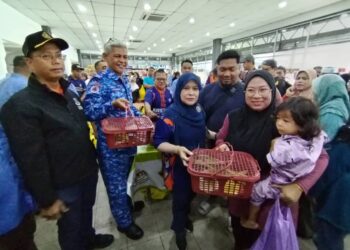 AMINUDDIN Zulkipli (dua dari kiri) mengagihkan bakul bantuan percuma kepada pengunjung Program Walkabout Jualan Ihsan Madani @ PTK Nyiur Tujuh di Besut, Terengganu. - UTUSAN/ WAN ZURATIKAH IFFAH WAN ZULKIFLI