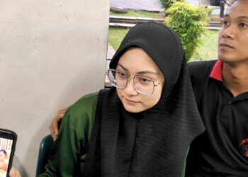 AINOL IZZAH Raslan dan Nazrul Nizam Mohd. Tahar menunjukkan gambar Harraz Noah Nazrul Nizam diberikan makan pisang ketika ditemui di Jabatan Perubatan Forensik Hospital Melaka.