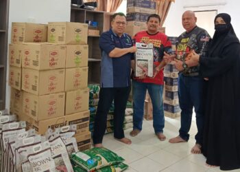 ZUHAIRI Ab. Kadir (kiri) menyampaikan sumbangan kepada petani terjejas banjir dari Maran di bilik gerakan operasi PPNP di Gambang, Kuantan, Pahang.