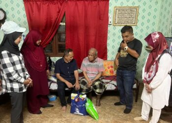 RAZAK Daud (tiga dari kiri) menyantuni sebuah keluarga dalam program Ziarah Kasih di Felda Jengka 24 di Jerantut, Pahang.