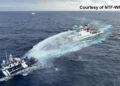 This handout taken and released on December 4, 2024 by the National Task Force for the West Philippine Sea (NTF-WPS) shows a China Coast Guard ship (R) deploying water cannon at the Phillipine Bureau of Fisheries and Aquatic Resources (BFAR) vessel BRP Datu Pagbuaya (L) near Scarborough Shoal in disputed waters of the South China Sea. The Philippines said the China Coast Guard fired water cannon December 4 on a government vessel during a maritime patrol near the disputed Scarborough Shoal. (Photo by Handout / National Task Force for the West Philippine Sea (NTF-WPS) / AFP) / RESTRICTED TO EDITORIAL USE - MANDATORY CREDIT "AFP PHOTO / National Task Force for the West Philippine Sea (NTF-WPS)" - NO MARKETING NO ADVERTISING CAMPAIGNS - DISTRIBUTED AS A SERVICE TO CLIENTS