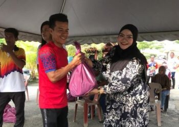 MARINA Talib (kanan) selaku wakil Misi Bantuan Baniir Pantai Timur Bersama Sahabat-Sahabat Amal dan Team Gerobok Iman Hawa (GIH) menyampaikan bakul makanan kepada nelayan di Kampung Tanjung Kuala, Sabak, Kota Bharu, Kelantan. - UTUSAN/ROSLIZA MOHAMED