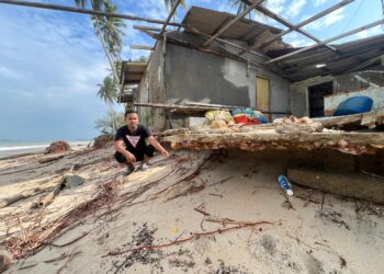 MUHAMMAD Luqman Mohd. Noor menunjukkan kesan hakisan teruk menyebabkan rumahnya rosak di Pantai Bisikan Bayu Semerak, Pasir Puteh, Kelantan semalam. – UTUSAN/TOREK 
SULONG