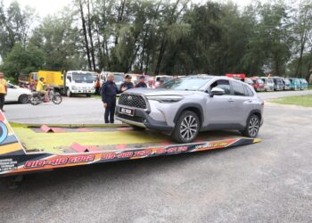 SEBUAH kereta yang rosak akIbat banjir dibawa dengan trak tunda ke bengkel pada Program Komuniti Ibu pejabat Polis Daerah Tumpat,di Pantai Sri Tujuh, Tumpat, Kelantan. - MINGGUAN/ ROHANA MOHD. NAWI