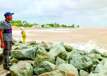 PENDUDUK melihat kawasan pesisir pantai di Kampung Sabak di Kota Bharu, Kelantan. -  UTUSAN/ ROSLIZA MOHAMED