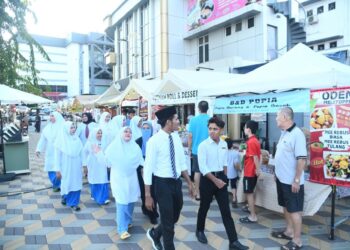 PENIAGA dan pengunjung mengenakan pakaian sekolah sekali gus mengimbau kembali nostalgia zaman persekolahan di pasar lokal, Kangar Street Art, pekan lama Kangar, Perlis semalam.-UTUSAN/IZLIZAN OTHMAN