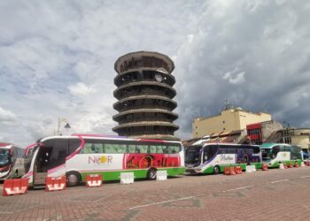 DERETAN bas membawa pelancong melawat Menara Condong Teluk Intan ketika tinjauan semalam. - UTUSAN/AIN SAFRE BIDIN