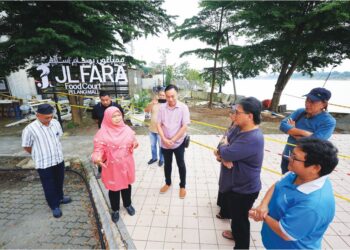 DR. Hafidzah Mustakim (dua kanan) meninjau lokasi runtuhan tebing Sungai Kelantan berhampiran Pelangi Mall di Kota Bharu, semalam. 
– UTUSAN/KAMATUL BISMI KAMARUZAMAN