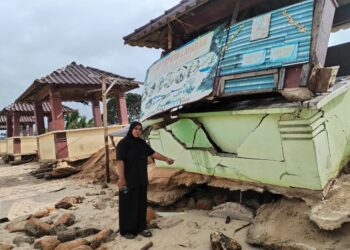 AZLIEYA Rosli menunjukkan keadaan gerainya yang roboh akibat hakisan pantai di Pantai Teluk Bayu, Besut, Terengganu. – UTUSAN / WAN ZURATIKAH IFFAH WAN ZULKIFLI