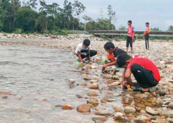 KANAK-KANAK mencari anak ikan kelah merah di tepi Sungai Berang, Kampung Belukar Bukit, Hulu Terengganu. - UTUSAN/ NOOR HAYATI MAMAT