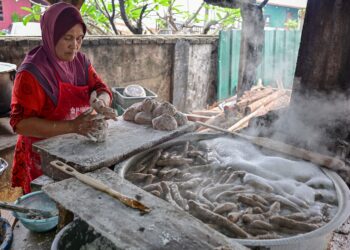 Pengusaha keropok lekor menguli campuran ikan tamban, tepung, sagu dan tiga perisa untuk membentuk keropok lekor sebelum dijual kedai Keropok Mokcik Nah di Kampung Tanjung, Batu Rakit. -UTUSAN/PUQTRA HAIRRY