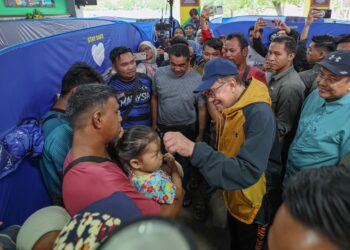 ANWAR Ibrahim menyantuni mangsa banjir ketika melawat Pusat Pemindahan Sementara di Sekolah Kebangsaan Telaga papan, Bandar Permaisuri, Terengganu semalam. - UTUSAN/PUQTRA HAIRRY