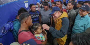 ANWAR Ibrahim menyantuni mangsa banjir ketika melawat Pusat Pemindahan Sementara di Sekolah Kebangsaan Telaga papan, Bandar Permaisuri, Terengganu semalam. - UTUSAN/PUQTRA HAIRRY