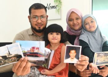 ABD. RAZAQ Syukri bersama isteri dan anak-anaknya menunjukkan gambar-gambar tragedi tsunami Aceh pada 2004 yang mengorbankan ratusan ribu nyawa dan memusnahkan banda Aceh ketika ditemui 
di Kampung Sungai Berembang, Simpang Empat, Arau, Perlis, baru-baru ini. – UTUSAN/IZLIZAN OTHMAN