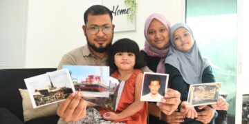 ABD. RAZAQ Syukri bersama isteri dan anak-anaknya menunjukkan gambar-gambar tragedi tsunami Aceh pada 2004 yang mengorbankan ratusan ribu nyawa dan memusnahkan banda Aceh ketika ditemui 
di Kampung Sungai Berembang, Simpang Empat, Arau, Perlis, baru-baru ini. – UTUSAN/IZLIZAN OTHMAN