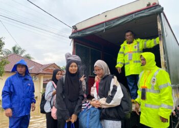 SEBAHAGIAN pelajar yang dibawa berpindah ke asrama Kampus Gong Badak  dibantu oleh Task Force Banjir Universiti Sultan Zainal Abidin (UniSZA) selepas rumah mereka dinaiki air di Kuala Nerus, Terengganu.