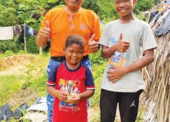 AKOP a/l Mua (berdiri, kanan) bersama Roslan Abu Kassim (kiri) di Kampung Orang Asli Dedari, Taman Negara Kuala Tahan, Jerantut.