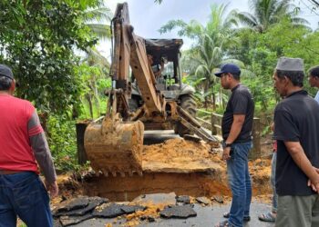 TENGKU Harith Tengku Aziz (kanan) melihat kerja-kerja membaik pulih lubam benam di Kampung Alor Pasir, Gaal, Pasir Puteh, Kelantan. - UTUSAN/TOREK SULONG