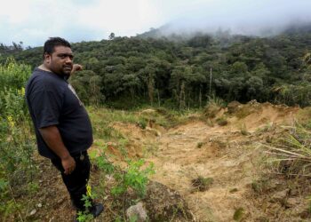 A. Dilip Martin menunjukkan kawasan ditambah tanah sehingga menyebabkan anak Sungai Jasar di bawahnya dipenuhi tanah. – MINGGUAN/MUHAMAD NAZREEN SYAH MUSTHAFA