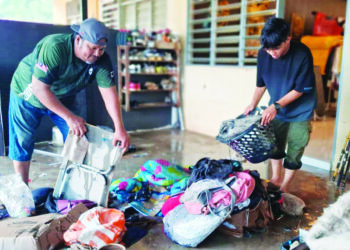 ZAINURI Ismail dibantu anaknya membersihkan rumah mereka di perumahan Taman Rakyat Teluk Kalong, Kemaman, Terengganu. - UTUSAN/NIK NUR IZZATUL HAZWANI NIK ADNAN