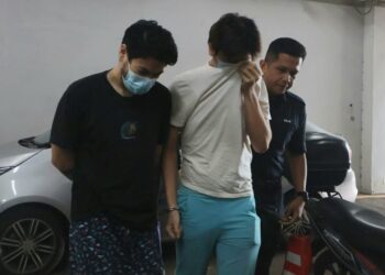 LEE Ho Meng dan Heng Xavier diiringi oleh seorang anggota polis (kanan) ketika tiba di Mahkamah Sesyen Butterworth, Pulau Pinang hari ini.-UTUSAN/IQBAL HAMDAN