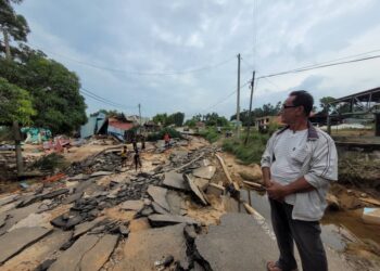 KEADAAN Jalan Jubakar Pantai, Tumpat, Kelantan yang rosak dibadai arus deras semasa bah melanda kawasan itu pada Rabu lalu.-UTUSAN/MUSTAQIM MOHAMED.