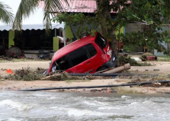 SEBUAH kereta mengalami kerosakan selepas dihanyutkan arus deras banjir berhampiran Taman Sri Bayu, 
Kampung Jubakar, Tumpat, Kelantan. – UTUSAN/KAMARUL BISMI KAMARUZAMAN