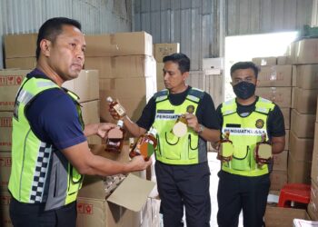 MOHD. Suffian Mohd. Abass (tengah) menunjukkan sebahagian daripada arak tiruan yang dirampas dalam satu serbuan di sebuah gudang lama di Jalan Permatang Batu, Bukit Mertajam, Pulau Pinang.UTUSAN/ISWAN SHAFIQ ISA