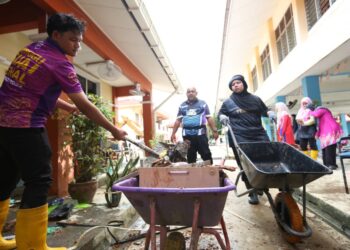 SUKARELAWAN Universiti Utara Malaysia (UUM) turun membantu membersihkan kesan banjir di sebuah sekolah yang ditenggelami air di Pasir Mas, Kelantan-IHSAN UUM.