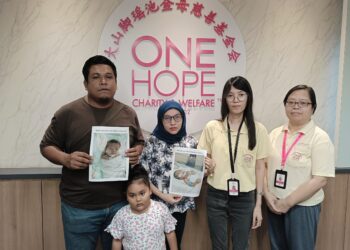 MOHD. Faiz Fakrumie (kiri) bersama isteri, Norazlini Mohd Nor (dua dari kiri) dan anak perempuan mereka menunjukkan gambar Muhammad Ammar Arfan ketika datang ke pejabat One Hope Charity and Welfare di Bukit Mertajam, Pulau Pinang baru-baru ini