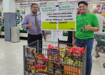 MAS IMRAN Adam (kanan) dan seorang petugas Econsave menunjukkan bakul rezeki yang ditempatkan di salah sebuah cawangan pasar raya Econsave di Johor.