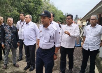 RUJI Ubi (depan) semasa turun padang melihat kerosakan akibat bah yang melanda SMK Meranti, Pasir Mas, Kelantan.UTUSAN/ROHANA ISMAIL.