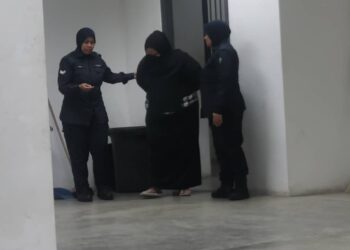 ANGGOTA polis mengiringi tertuduh (tengah) selepas didakwa atas pertuduhan menawarkan khidmat seks melalui aplikasi WeChat di Mahkamah Majistret Kota Bharu, Kelantan hari ini.-UTUSAN/ROSALWANI CHE SOH