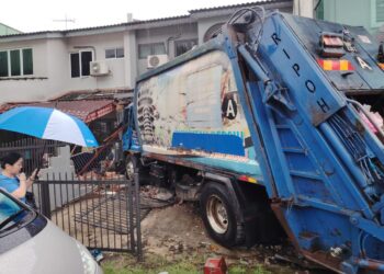 LORI sampah yang terbabas dan melanggar tiga buah rumah di Taman Bukit Mewah, di sini, semalam.