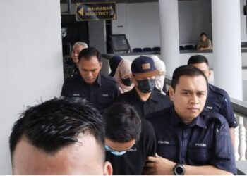 TERTUDUH yang juga seorang Datuk Seri (bertopi) bersama empat individu lain diiringi polis ketika dihadapkan ke Mahkamah Majistret Ayer Keroh, Melaka, hari ini.