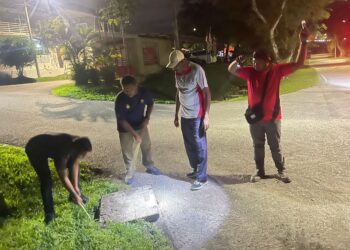 R. THANABALAN (dua dari kanan) bersama ahli Skuad Pantas Nilai dan JPKK Kampung Nilai, Batang Benar, Nilai bersama-sama menutup semula lubang sistem utiliti yang dikesan hilang penutupnya di beberapa kawasan di sekitar Nilai, Seremban.