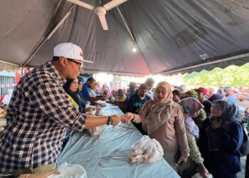 MOHD. Syahbuddin Hashim (kiri) menjual ayam kepada penduduk di pekarangan Pusat Khidmat Ahli Dewan Undangan Negeri (ADUN) Galas di Bandar Utama, Gua Musang, Kelantan. – UTUSAN/AIMUNI TUAN LAH