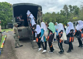 Angkatan Tentera Malaysia (ATM) membawa pelajar menaiki trak berikutan laluan yang masih dinaiki air ke Sekolah Menengah Kebangsaan Dato Awang Jabar, Merchang, Marang, Terengganu. - IHSAN ATM