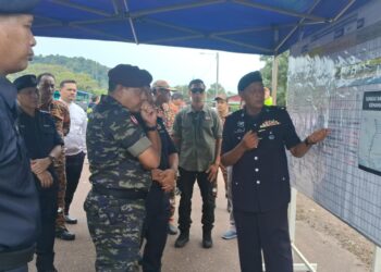 AYOB Khan Mydin Pitchay  (tengah) mendengar taklimat ketika meninjau keadaan banjir di perumahan Taman Rakyat Teluk Kalong, Kemaman, Terengganu, hari ini. - UTUSAN/NIK NUR IZZATUL HAZWANI NIK ADNAN