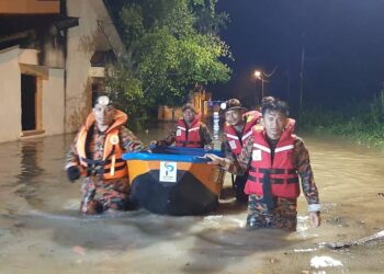 ANGGOTA bomba memindahkan penduduk yang terjejas banjir di Pantai Remis hari ini. - UTUSAN/JBPM