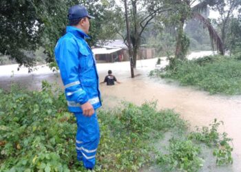 ANGGOTA Angkatan Pertahanan Awam (APM) melakukan pemantauan di kawasan yang mula dinaiki air di Tanah Merah, Kelantan. - IHSAN APM