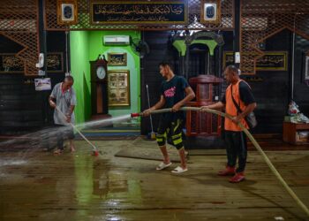 PENDUDUK membersihkan masjid yang dipenuhi lumpur ekoran banjir di Kampung Pasir Simpul, Kuala Berang, Hulu Terengganu hari ini. - UTUSAN/PUQTRA HAIRRY 