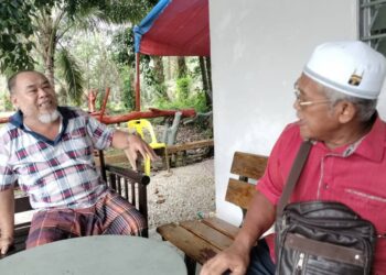 ROSIDIN Kanar (kiri) menerima kunjungan Ismail Sajidon di kediaman di Lorong 2, Kampung Palembang Baru, Kluang.