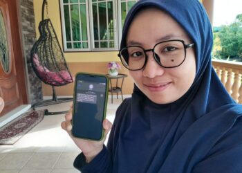 NUR SHAHIRAH Sulaiman menunjukkan tawaran menunaikan fardhu haji bagi tahun 2005 daripada TH di Kampung Puteri Menangis, Pontian.