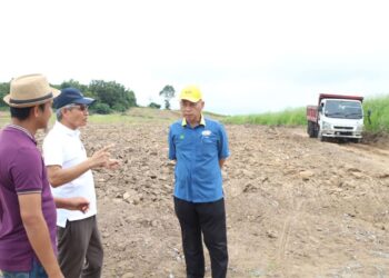 RAZALI Saad (kanan) ketika melawat kawasan tanaman nanas jenis MD2 di Chuping, Perlis semalam.-UTUSAN