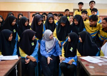 FADHLINA Sidek (tengah)  beramah mesra bersama pelajar ketika mengadakan lawatan kerja di Sekolah Menengah Kebangsaan (SMK) Kuala Jengal, Dungun, Terengganu. - UTUSAN/PUQTRA HAIRRY ROSLI