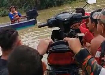 PASUKAN penyelamat dan orang ramai mengangkat motosikal yang dipercayai milik pemuda yang hanyut dibawa arus di sebuah ladang sawit di Felda Kerteh 3, Dungun, Terengganu.