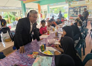 JELANI Sulong (kiri) beramah mesra dengan sebahagian kanak-kanak yang berada di pusat pemindahan sementara (PPS) SK Kompleks Gong Badak, Kuala Nerus, Terengganu, hari ini. - UTUSAN/KAMALIZA KAMARUDDIN