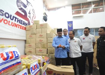 HASRIN KAMAL Hashim (kiri) melihat barang makanan yang akan dihantar kepada mangsa banjir di negeri ini di Pejabat Penolong Setiausaha Kerajaan Johor (Belia, Sukan & Sukarelawan) di Iskandar Puteri.